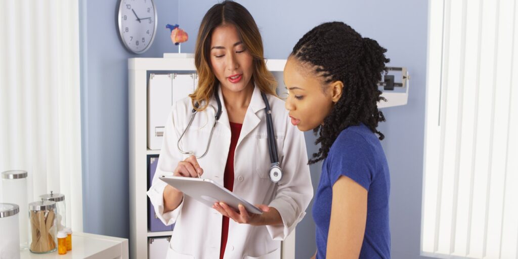 Young female physician consults female patient