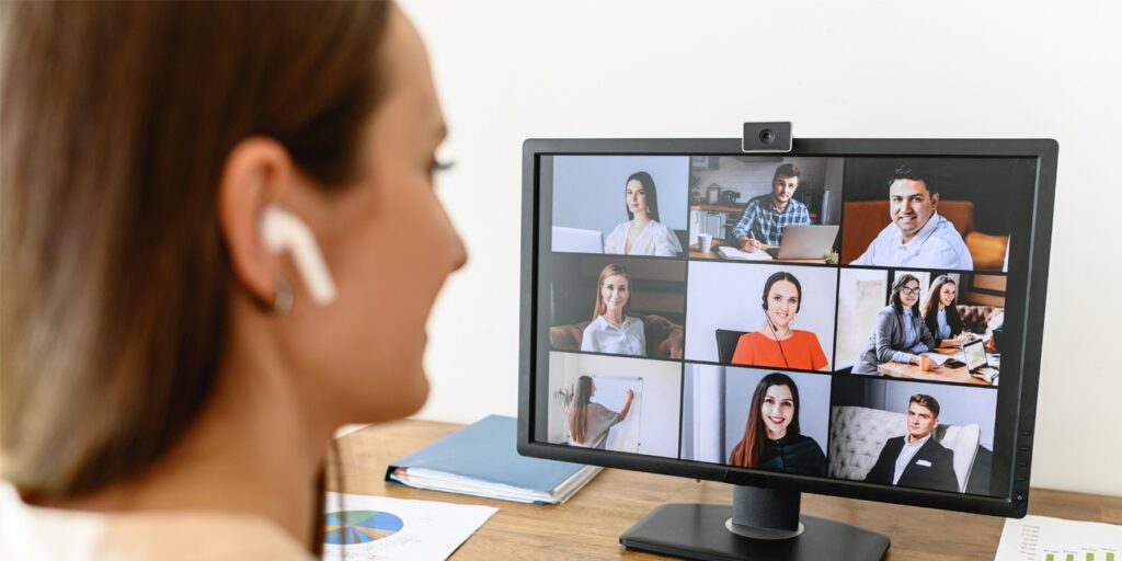 Young female employee hosting video conference with team